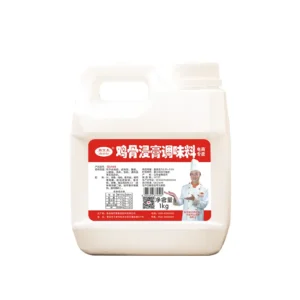 Una jarra blanca de plástico de 1 kg de condimento Ruikelai Global Chicken Bone Extract Seasoning con una etiqueta china roja y blanca que muestra a un chef sonriente sosteniendo un pequeño recipiente de condimento.