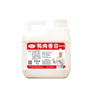 Una jarra de plástico blanca de 1 kg de pasta de sabor a carne de pato Ruikelai Global con una etiqueta china roja y blanca en la que aparece un chef sonriente con uniforme blanco y toca, sosteniendo un pequeño recipiente de condimento.